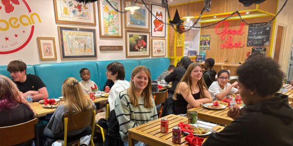 Young carers from Action for Family Carers’ Loughton Young Carers Club enjoying a Caribbean meal together at Café Caribbean in Loughton to celebrate Black History Month.