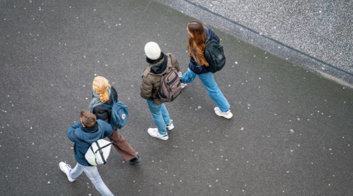 "Group of young people walking together with backpacks, representing young carers balancing school life and caring responsibilities – used for an Action for Family Carers case study story."