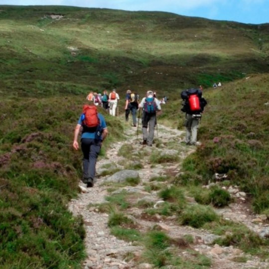 group of people walking with rucksacks completing the 3 peaks challenge
