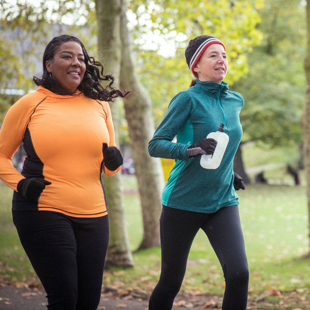 Three people jogging together through a park, promoting London Marathon charity places for Action for Family Carers.